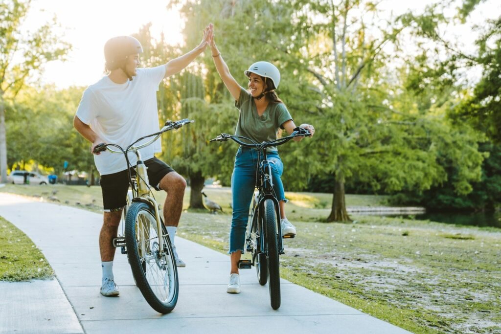 a man and a woman on bicycles giving each other a high five