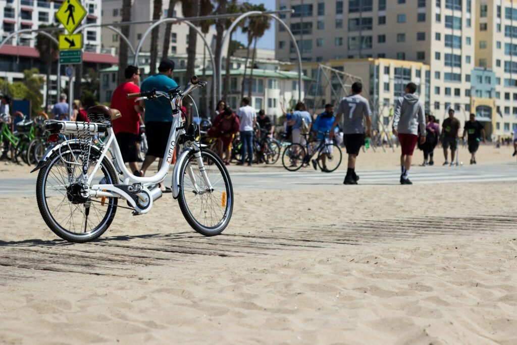 a white bike parked on top of a sandy beach
