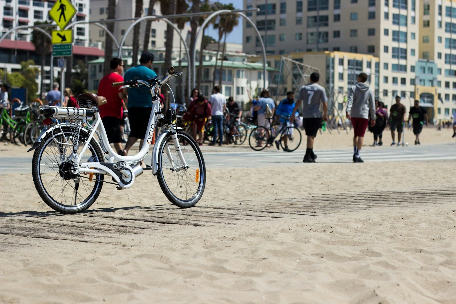 a white bike parked on top of a sandy beach