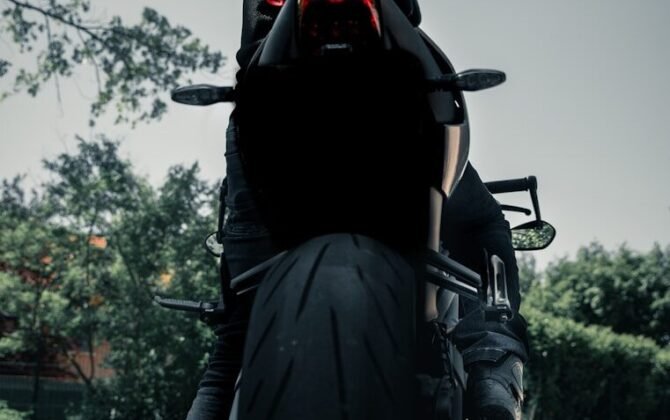 man in black leather jacket riding black motorcycle